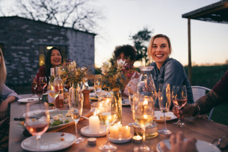 Group of friends enjoying outdoor party in garden restaurant . Millennials enjoying dinner outdoors